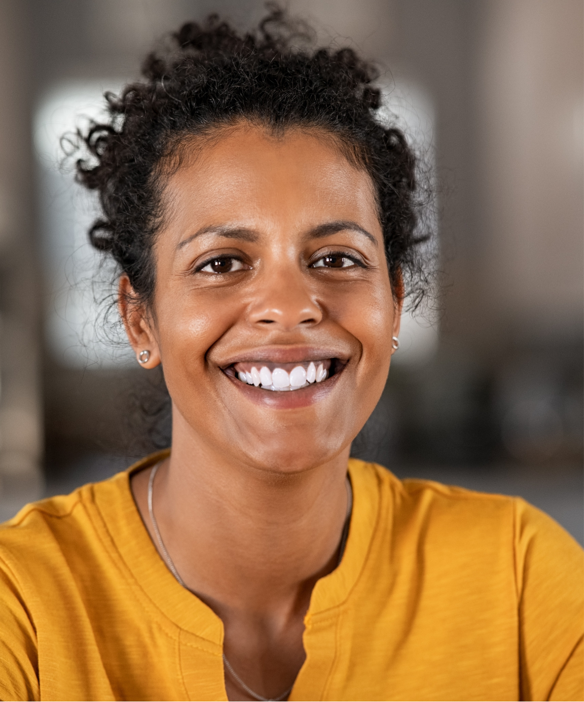 Smiling woman wearing a yellow shirt