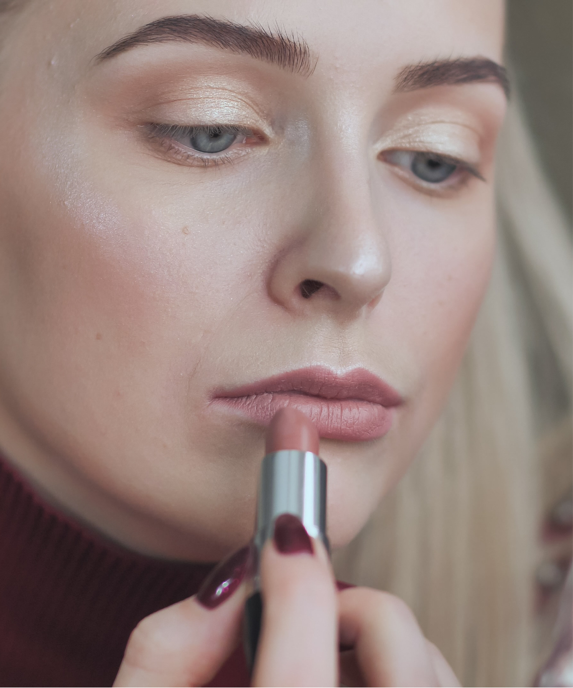 Woman with dull lip color applying lipstick