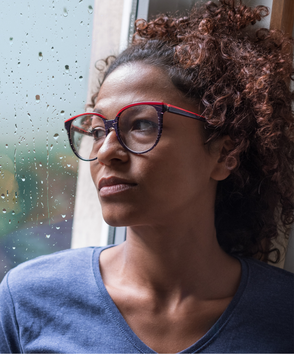 Woman staring out a rainy window