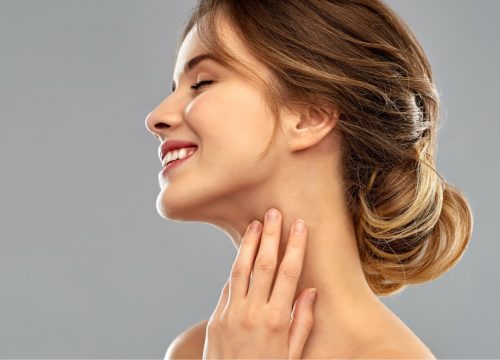 Woman touching her submental area after KYBELLA® treatments