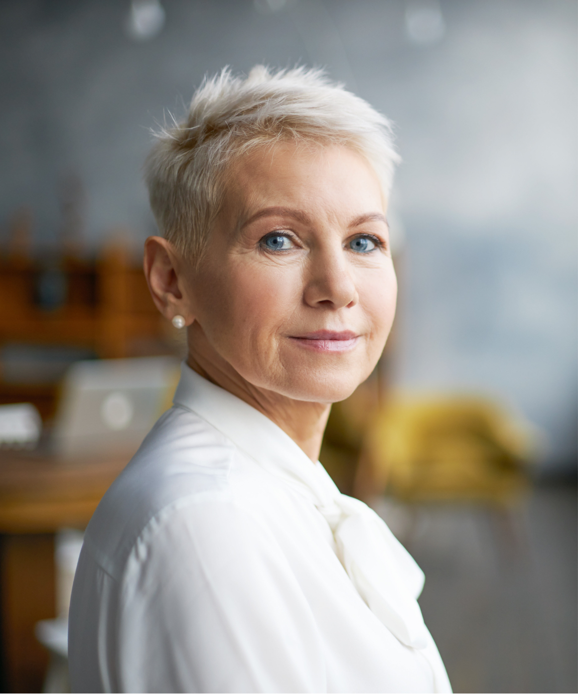 Older woman with short hair and peal earrings