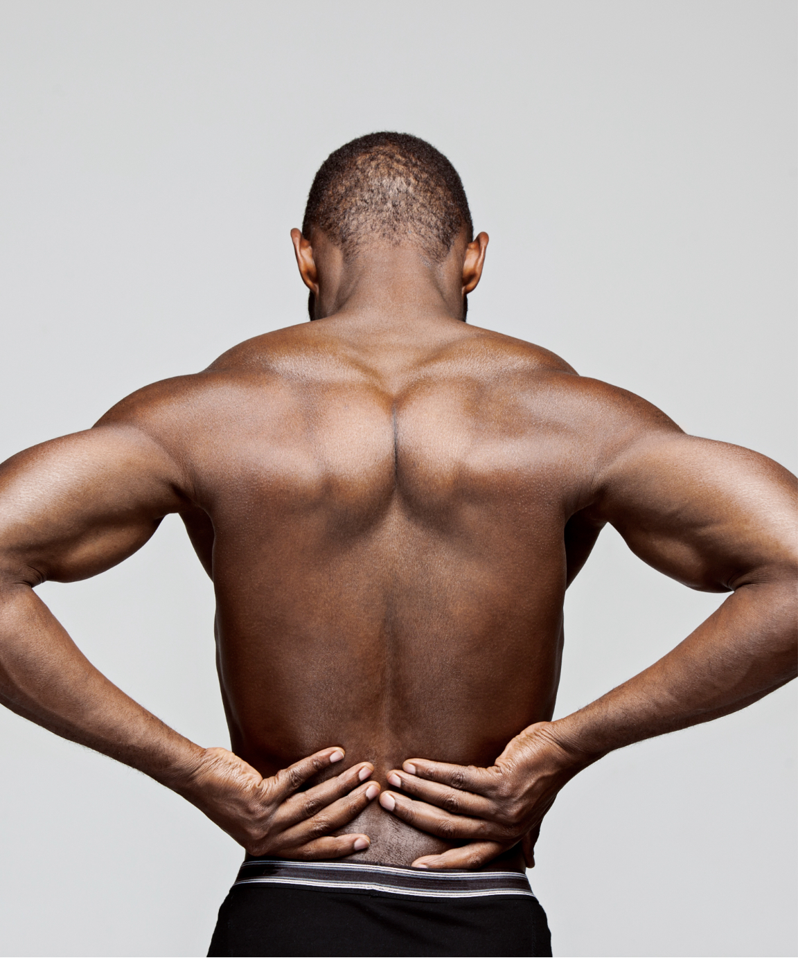 Muscular man touching his lower back