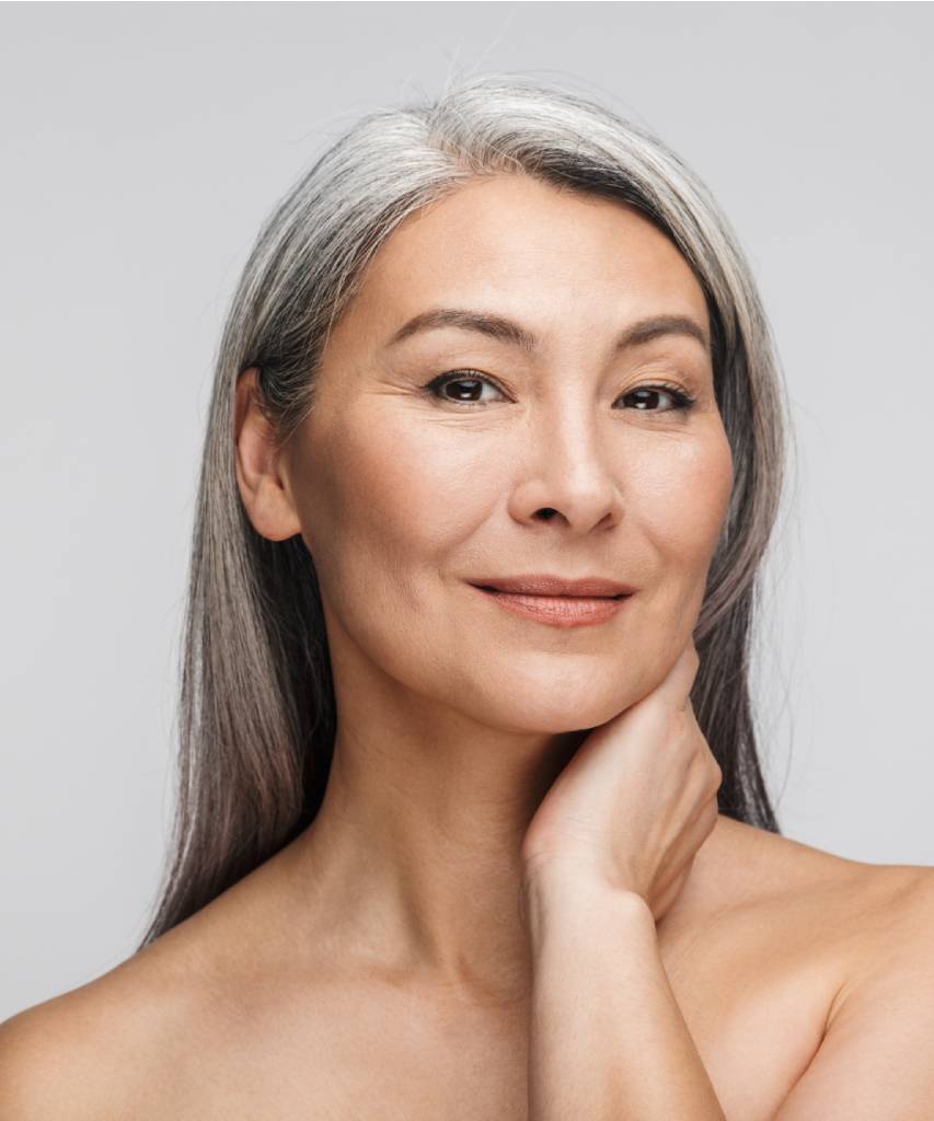 Woman with gray hair touching her neck
